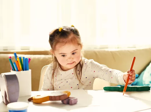 a child drawing on paper with pencil